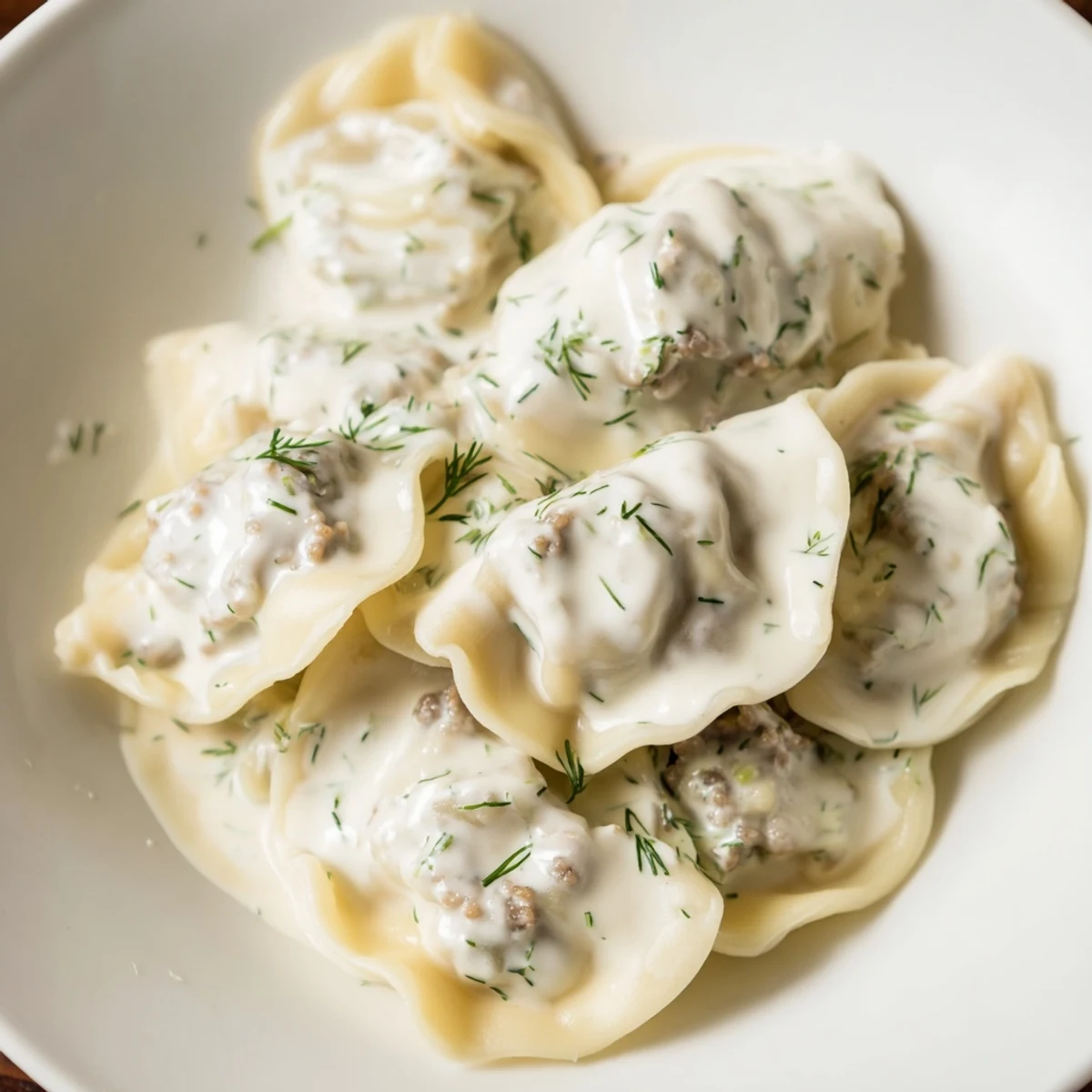 A close-up of savory Russian Pelmeni: tender dumplings swimming in a light broth, ready to eat.