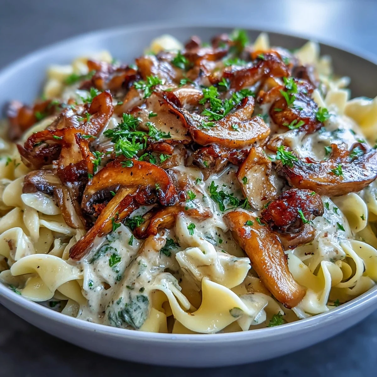 Creamy Mushroom Stroganoff served over wide fettuccine noodles, garnished with fresh parsley and black pepper for a comforting vegetarian dinner.