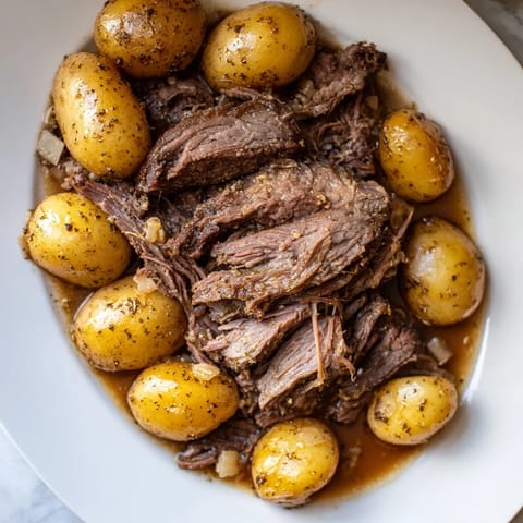 Hearty slow cooker pot roast with golden potatoes, a simple and comforting American classic.
