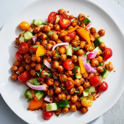 A bowl of delicious BBQ Chickpea Salad, featuring red and yellow bell peppers alongside crisp cucumbers.