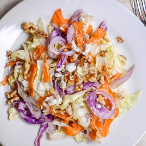 Cooked and Loved Cabbage Salad features vibrant vegetables with a honey-Dijon dressing and optional crunchy walnuts and feta.