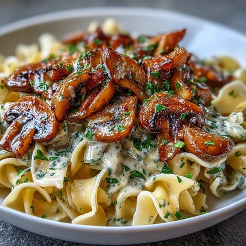 A skillet of Creamy Mushroom Stroganoff with sautéed mushrooms in a rich, tangy sauce, ready to be tossed with pasta for a weeknight meal.