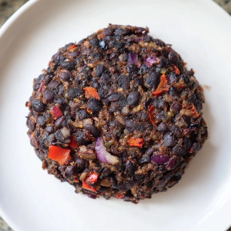 Stacking a juicy vegetarian black bean burger with fresh tomato, a perfect vegetarian meal option.