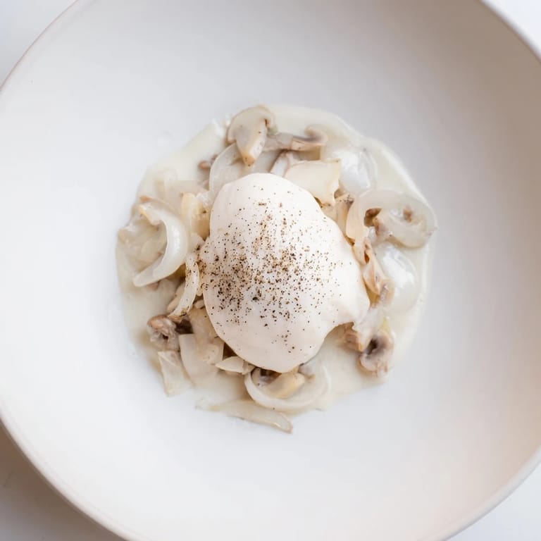 The Ghostly Gala showcases elegant white chicken atop a smooth cauliflower purée, ready to enjoy.