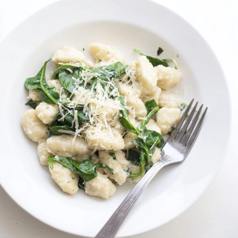 Serving of Creamy Garlic Gnocchi alongside a glass of Pinot Grigio for a cozy Italian dinner.
