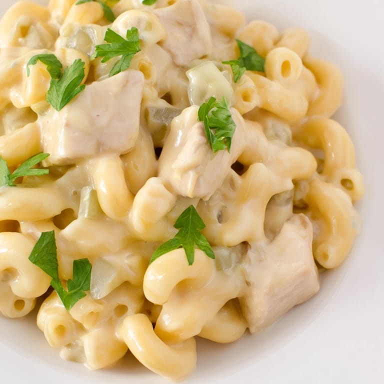 Easy weeknight Green Chili Chicken Mac served in a white bowl, featuring saucy elbow pasta, shredded sharp cheddar, and a blend of warm spices.